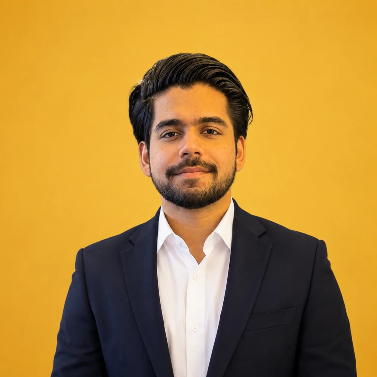 Muhammad Roushan in a dark suit against a yellow background